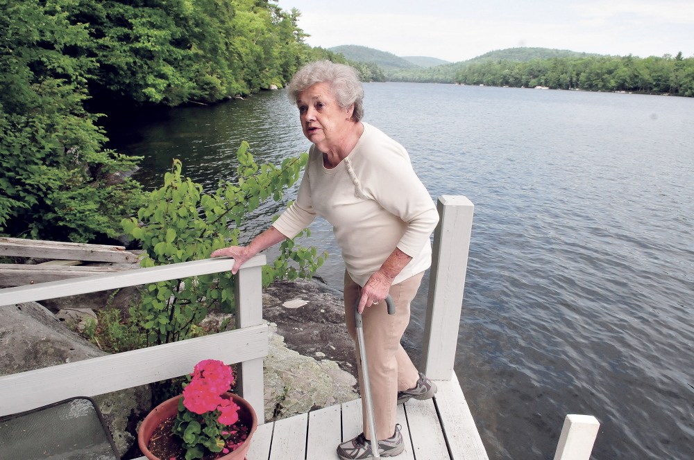 Doris Jorgensen speaks on July 14 about her concerns of a proposed children’s summer camp being built along the shore behind her on Long Pond beside her property in Rome.