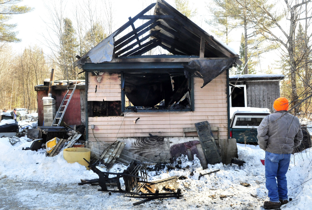 Larry Knox Sr. looks over the remains of his friend Maurice Bowring’s home on Monday. Knox is one of several friends helping Bowring after the fire last week.