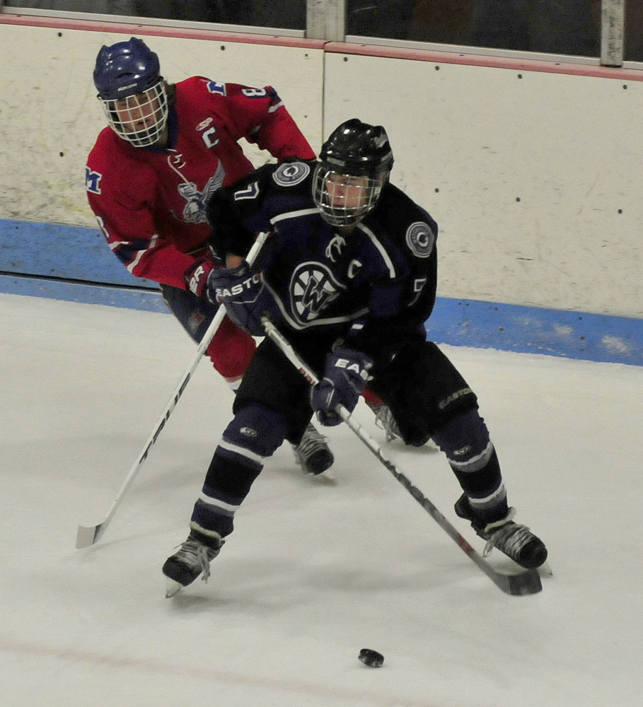 Waterville forward Nick Denis looks to shake Messalonskee defenseman Dylan Burton, back, during a Class B North game earlier this season at Sukee Arena in Winslow.