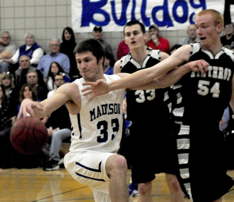 Madison’s Mitch Jarvais is pressured by Winthrop’s Garrett Tsouprake (33) and Anthony Owens during Mountain Valley Conference game Monday in Madison.