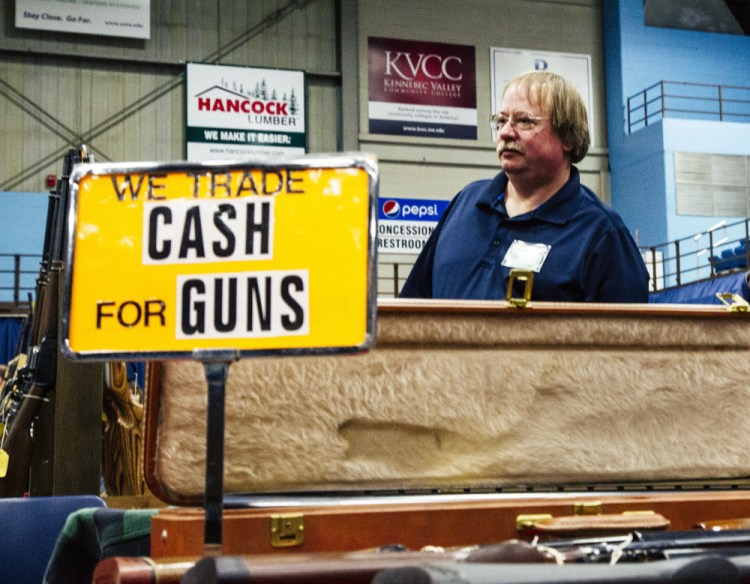 Craig Taylor of South China stands at his table at the gun show at the Augusta Civic Center on Saturday. Whitney Hayward/Staff Photographer