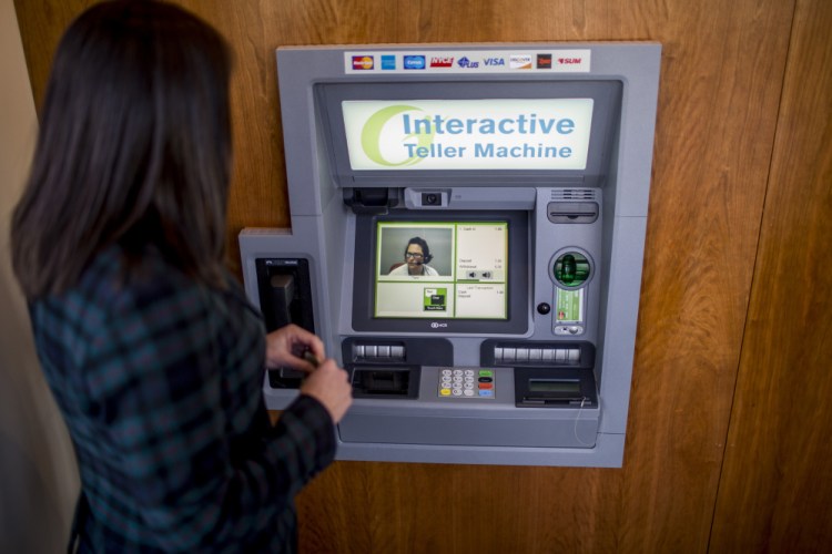 Becky Winslow, director of retail delivery for Gorham Savings Bank, demonstrates making a deposit using the bank's new Interactive Teller Machine on Munjoy Hill. A video feed of Toni, an interactive teller based in Gorham, pops up on the screen and guides Winslow through the deposit. (Photo by Gabe Souza/Staff Photographer)