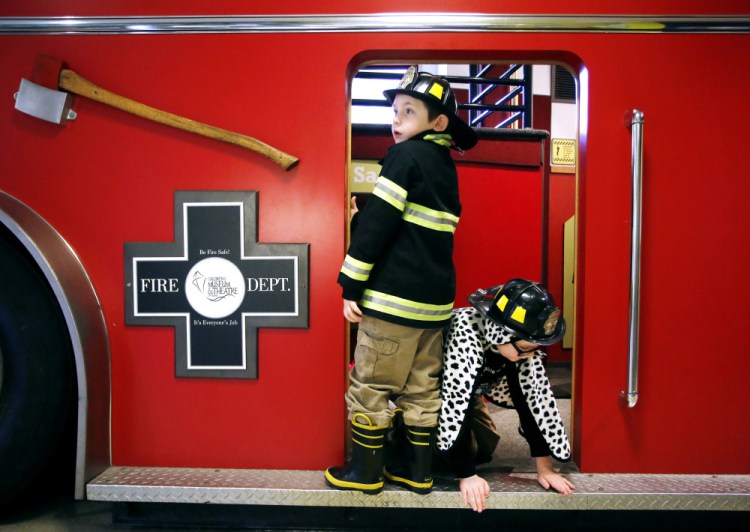  Jack Donovan, 6, left, of Scarborough and his brother Joey, 9, play on a firetruck exhibit. Derek Davis/Staff Photographer