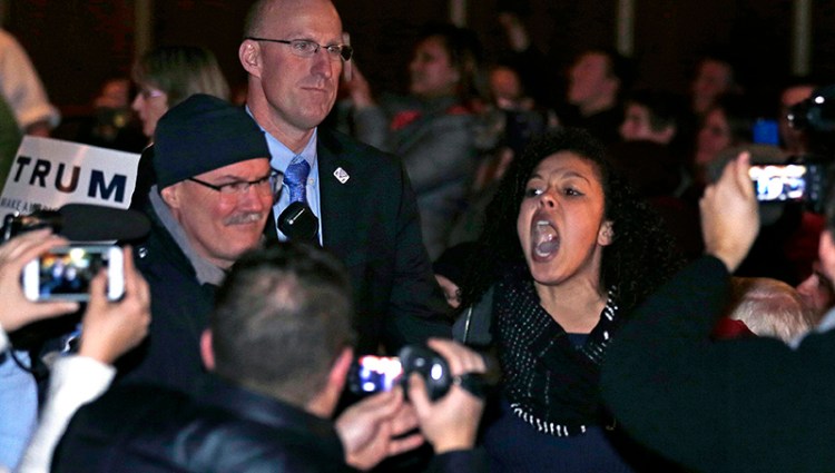 A protestor yells as she is escorted by security out of the audience during an address by Donald Trump at a campaign stop in Burlington, Vt., Thursday.