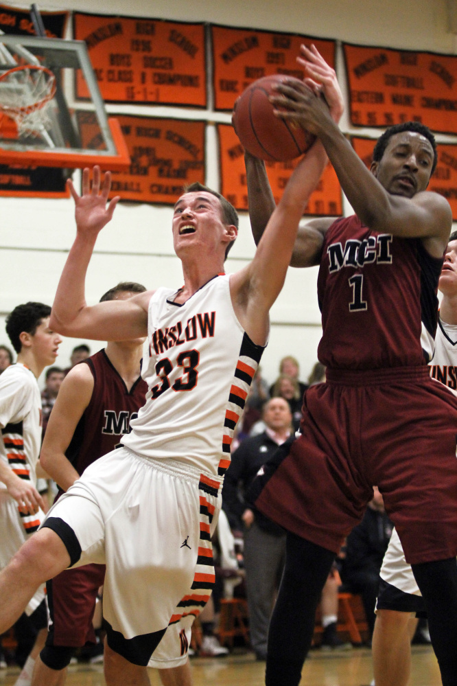 Winslow High School’s Justin Burgher (33) battles for a rebound with Maine Central Institute’s Tre Grier during the first half of a Class B North preliminary playoff game Wednesday in Winslow.