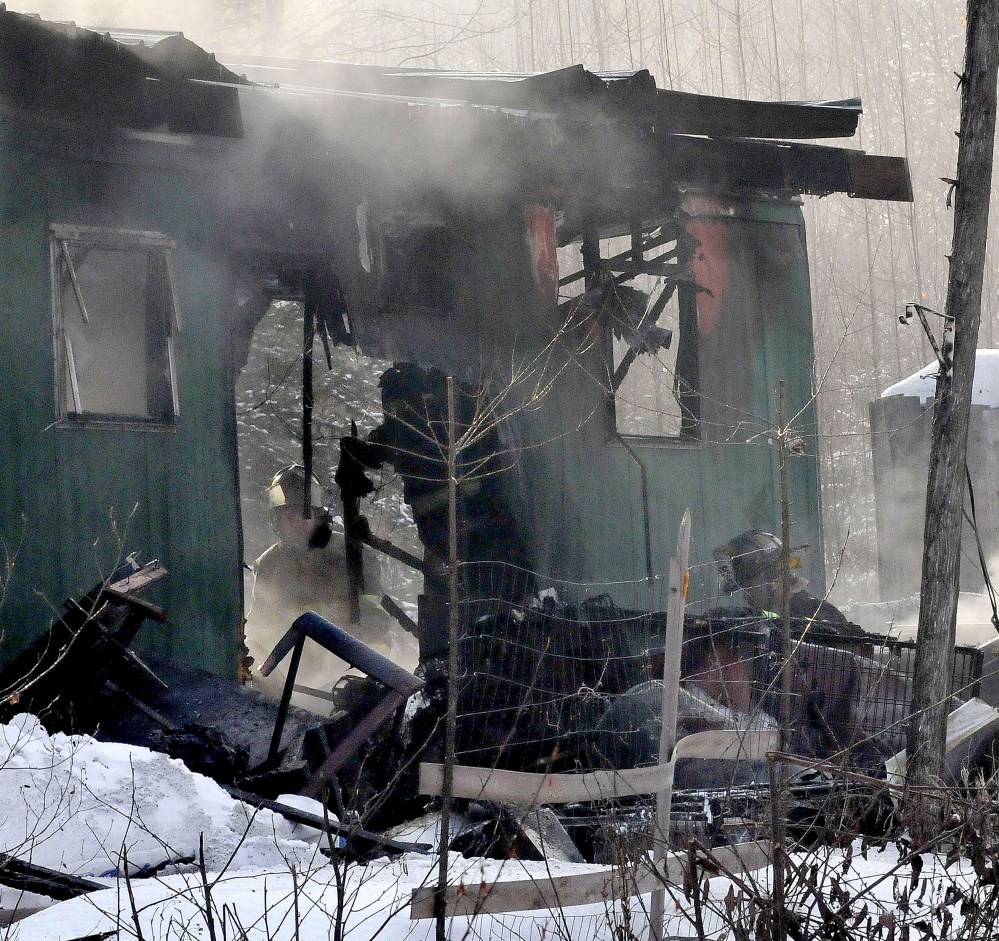 A firefighter can be seen through the burned walls of a home on Horseback Road in Anson that was destroyed by fire early Thursday.