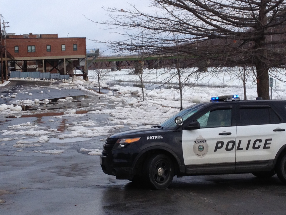 Augusta police and public works crews block off Front Street in Augusta because of Kennebec River flooding.