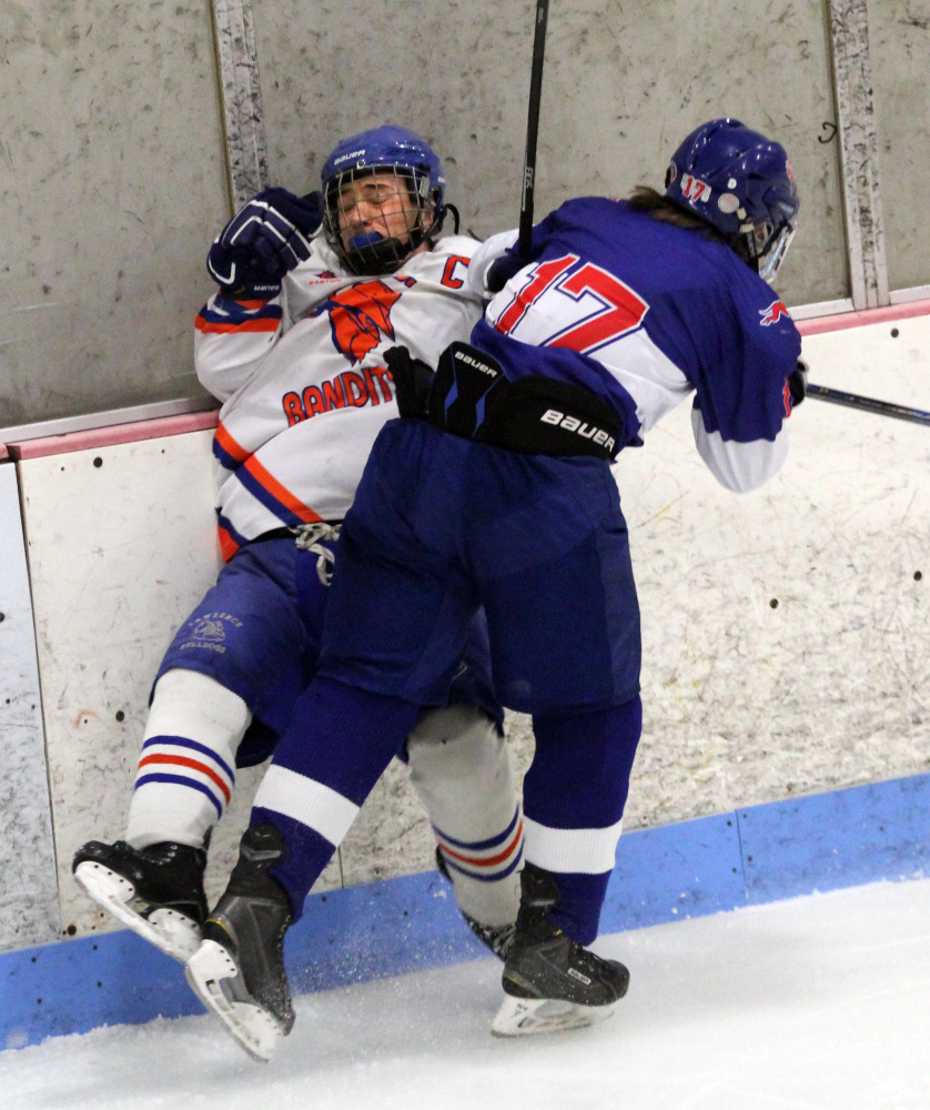Skowhegan/Lawrence defenseman Samuel Haver takes a hit from Mt. Ararat/Lisbon/Morse’s Sam Alexander during second period action at Sukee Arena in Winslow on Wednesday night.