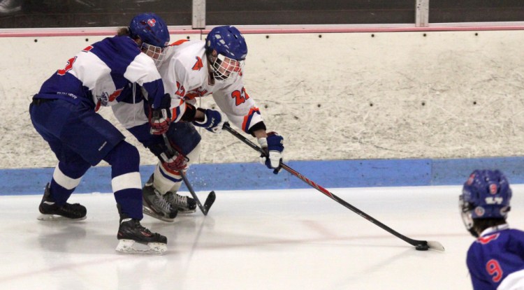 Skowhegan/Lawrence forward Brady Martin tries to skate by Mt. Ararat/Lisbon/Morse’s Andrew Gardiner during second period action at Sukee Arena in Winslow on Wednesday night.