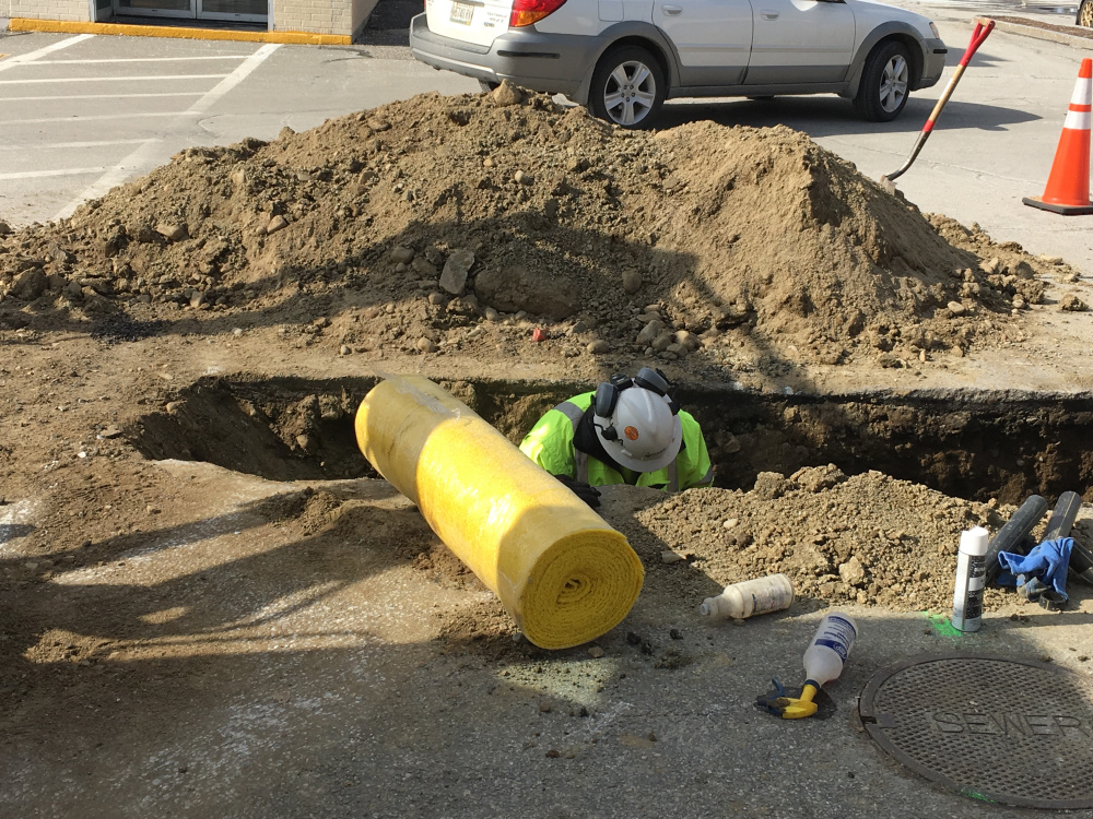 Summit Natural Gas pipeline inspector Joe Michaud works in a hole Thursday afternoon on repairs to a gas leak. Michaud said crews cut out a piece of the line that needed to be repaired.