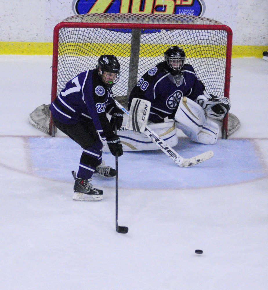 Waterville’s sophomore defenseman Chase Wheeler stands in front of goalie Nathan Pinnette during a game against Lewiston earlier this season at the Androscoggin Bank Colisee.