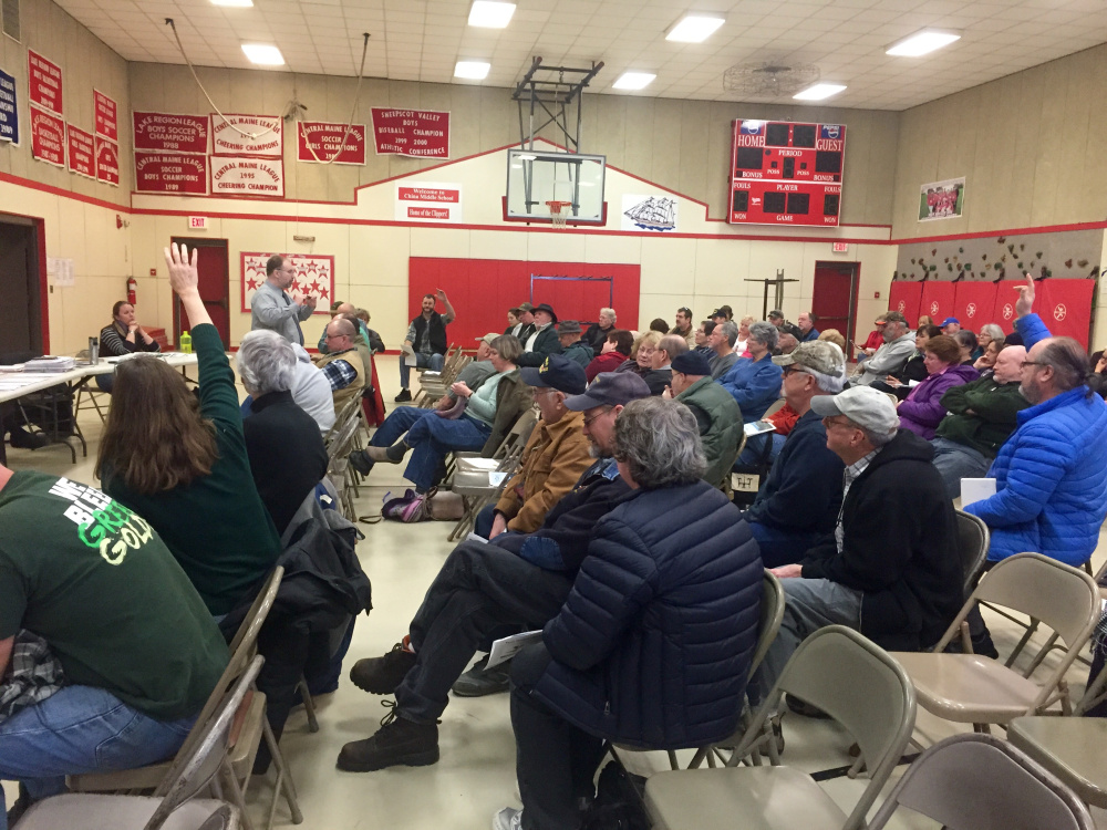 China residents raise their hands to ask questions during an informational meeting on a proposed pay-per-bag trash disposal program. Selectmen have agreed that rather than implementing a pilot program this summer, residents will vote on it in 2017 after strong opposition from residents.