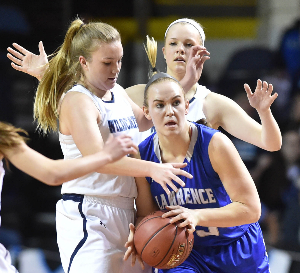 Lawrence senior center Nia Irving looks to pass as she is swarmed by York defenders during the Class A state championship game Saturday afternoon at the Cross Insurance Arena in Portland.