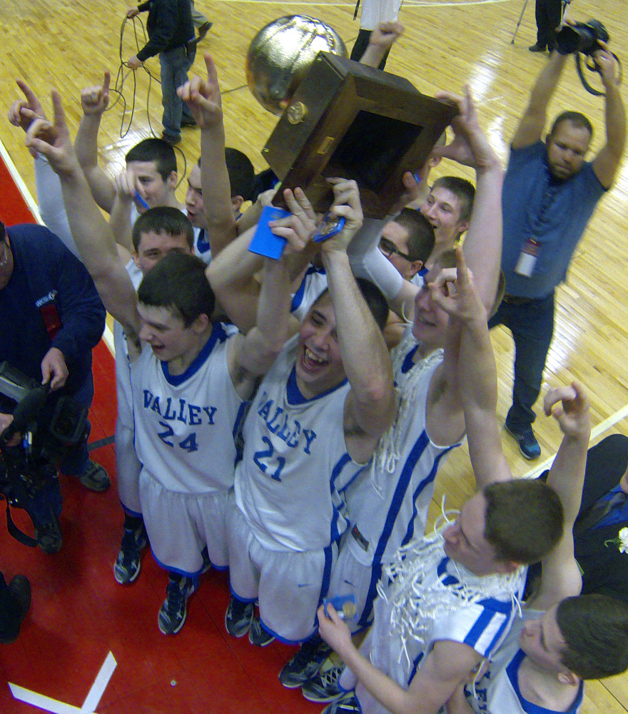 The Valley boys basketball team celebrates with the Gold Ball after it won the Class D state championship Saturday at Augusta Civic Center.