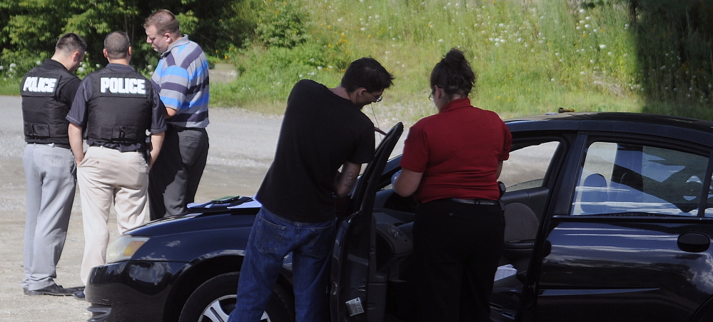 Augusta Police Department detectives confer in August 2015 under Memorial Bridge in Augusta while searching a vehicle following a robbery at the Big Apple store on Stone Street.