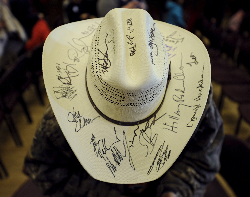 Jon Hathaway shows off a hat full of signatures that he has gathered from U.S. presidential candidates after a Bernie Sanders campaign rally Sunday at Iowa State University.