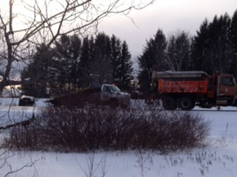 A wrecker, center, pulls a sport utility vehicle out of a ditch Saturday afternoon on the northbound side of Interstate 95 in Waterville, near the Trafton Road overpass.