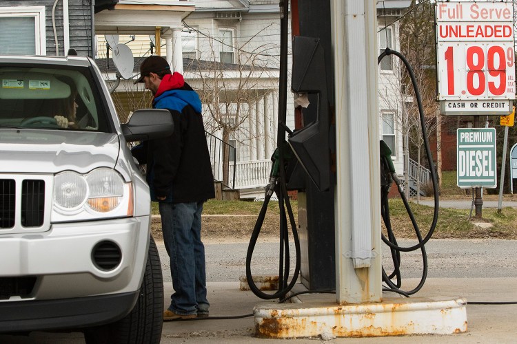 The sign at the Westbrook Auto Center reflects the sudden rise in gas prices as a motorist fills up his SUV on Monday.