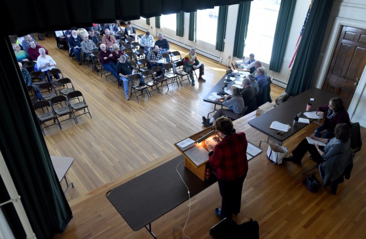 Susan Pratt, of Strong, stands at a lectern Saturday as she oversees the Town Meeting at the Strong Town Hall.