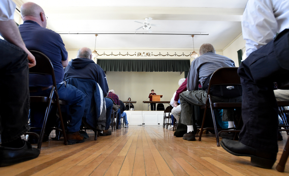 Susan Pratt, of Strong, stands at a lectern Saturday as she oversees the Town Meeting at the Strong Town Hall.