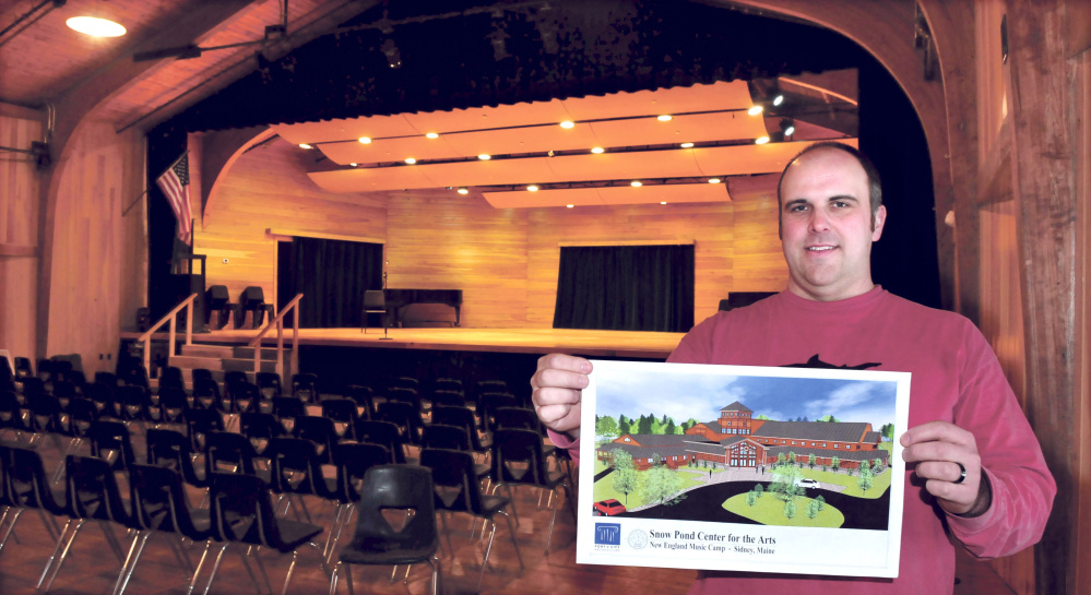 Snow Pond Arts Academy Dean of Students and Director of Admissions David Holinger, stands inside Alumni Hall holding a drawing of the proposed expansion project at the Sidney school on Monday. The enlarged building will have classrooms, offices, a theater and a performance area. The school and Oakland-based Regional School Unit 18 have agreed to share some services.