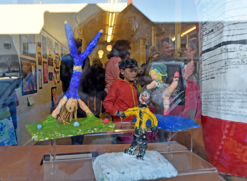 Kali Judkins, 8, inspects art work by her peers during the youth art show at Upcountry Artists Gallery in Farmington on Friday. The exhibition for Youth Art Month lasts until April 2, and a reception was held Friday night.