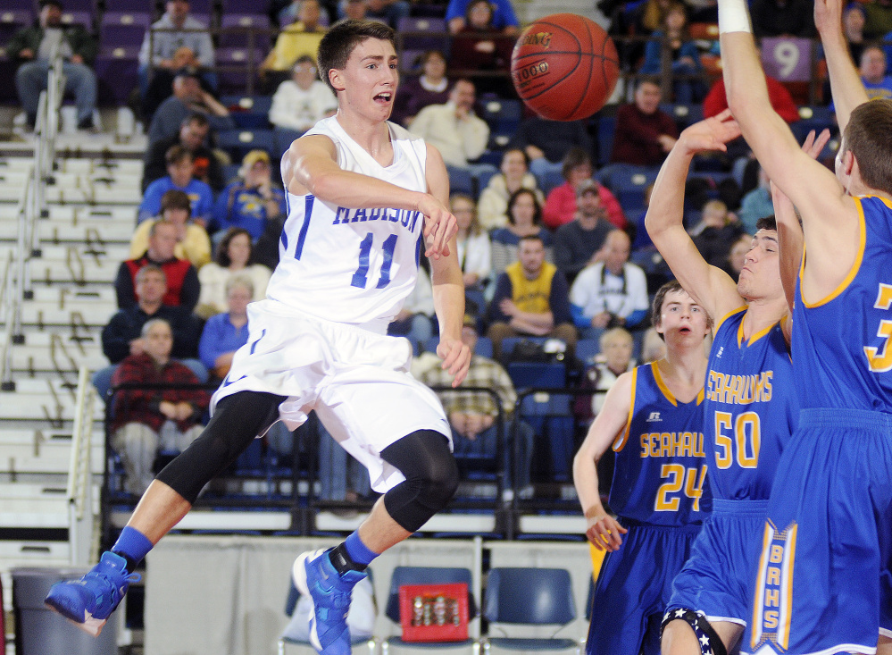 Madison senior forward Chase Malloy passes around Boothbay defenders during a Class C South quarterfinal this past season at the Augusta Civic Center.