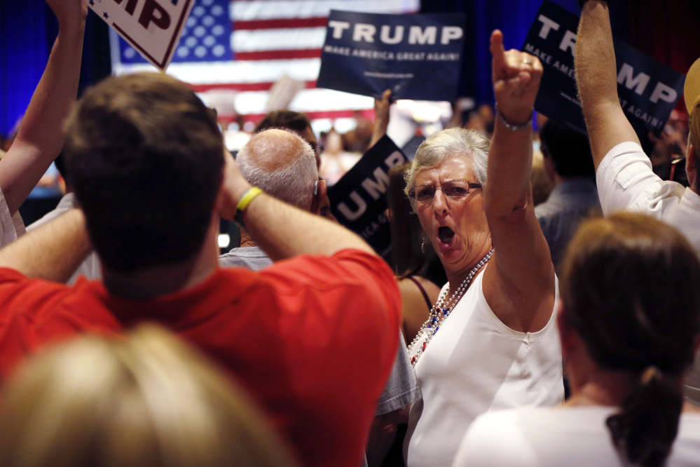 A woman turn around and gestures to the news media as former Alaska Gov. Sarah Palin, not pictured, talks about the news media, prior to Republican presidential candidate Donald Trump arriving at a campaign event in Tampa, Fla., Monday.