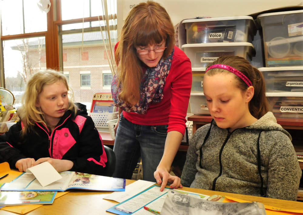 Carrabec High School student Autumn Holdworth assists Carrabec Community School students Kasey Littlefield, left, and Kiera Goodale with reading skills on Wednesday. Franklin County Literacy Volunteers and Americorps program are launching a new peer tutoring program in SAD 74. The program encourages middle, high school and elementary students to work together to improve literacy, with the high school volunteers teaching sixth graders reading skills and sixth graders in turn teaching first graders.