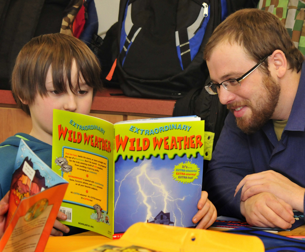 AmeriCorps Volunteer Coordinator Solomon Heifets assists Carrabec Community School student Devon Spencer with reading skills on Wednesday.