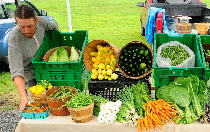 John Strieff sets up the 3 Level Farm booth for the Hallowell Farmers Market in this 2013 file photo taken at Granite City Park. Organizers are proposing to move the market to Vaughan Field Park.