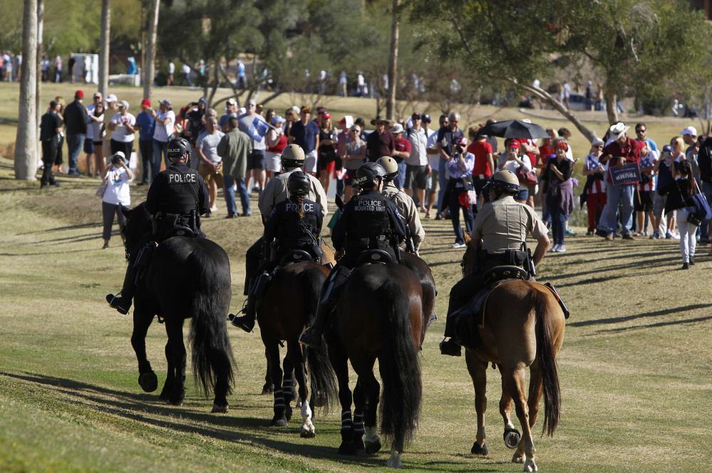 An Arizona police mounted unit patrols outside a Donald Trump campaign rally in Fountain Hills as supporters line up. Below, Alex Renner washes his eyes with bottled water at the scene of a protest against Trump on Saturday.