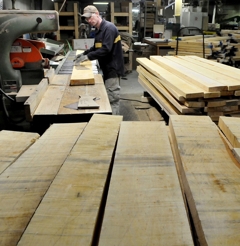 Mike Pelletier makes makes stencils of gunstocks on raw wood stock that will eventually be turned into finished gunstocks for firearms at Cousineau Wood Products in North Anson last year. Gov. Paul LePage plans to visit the company Friday morning .