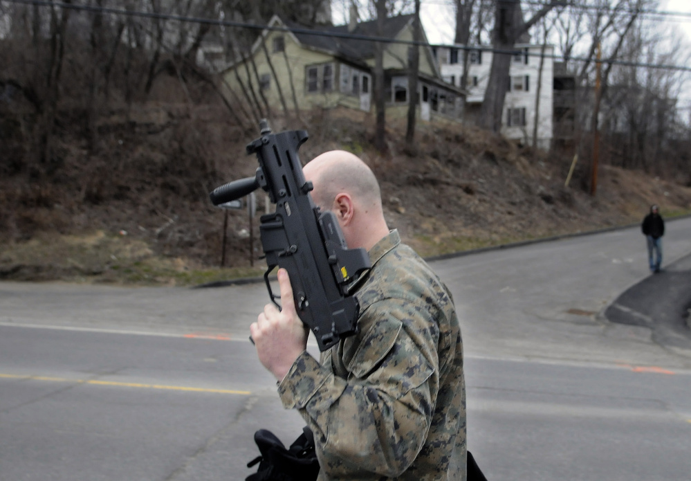 Augusta Police officer Donald Whitten returns Thursday to cruiser after assisting with the execution of search warrant at an apartment on Mount Vernon Avenue in the city.