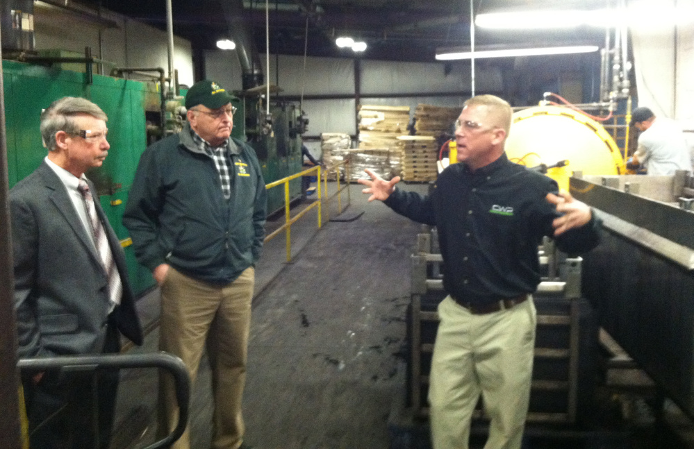 Brody Cousineau, right, explains the process Cousineau Wood Products uses to produce high-end wooden gun stocks during a tour of the company’s North Anson factory Friday.