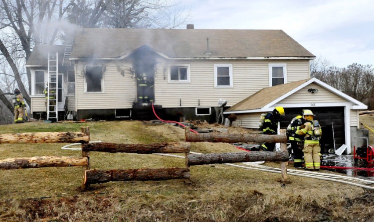 Firefighters from Smithfield, Oakland, Belgrade and Norridgewock fight a smoky fire that did serious damage to a home at 668 Village Road in Smithfield on Thursday.