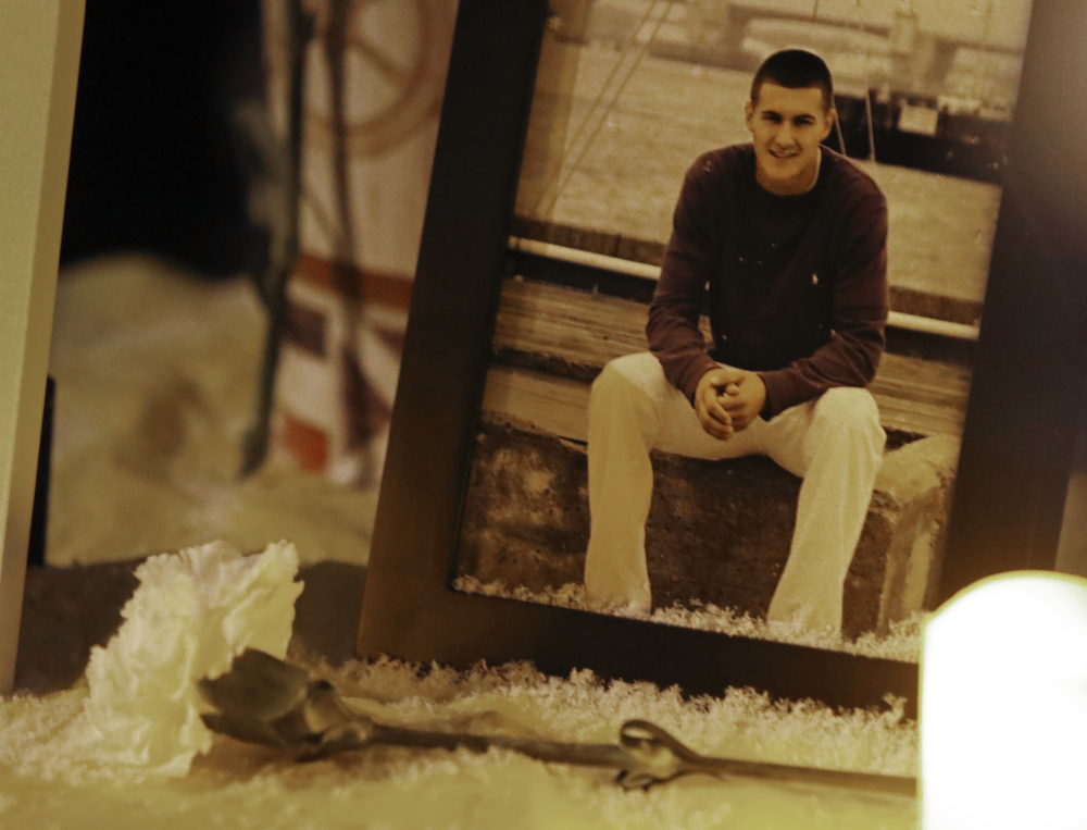 A carnation rests next to a photo of David Breunig on a table at Friday night’s vigil.