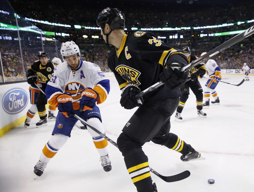 Boston’s Zdeno Chara, right, prepares to check New York’s Frans Nielsen during the Bruins’ 3-1 win Saturday in Boston.