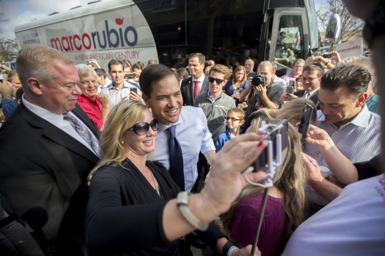 Republican presidential candidate Sen. Marco Rubio, R-Fla., poses for a photo with supporter Angela Newbill of Jacksonville at campaign stop at the Maple Street Biscuit Company in Jacksonville, Fla., on Monday. Rubio hopes his home-state voters defy the polls and give him justification to extend his candidacy.