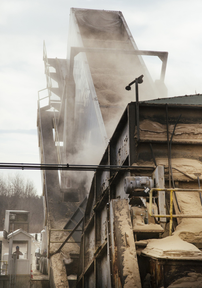A large truck unloads wood waste at the ReEnergy biomass plant in Livermore Falls. Loggers have sold the waste from forestry operations to the power plants for years. If the biomass market for the waste collapses, it would be a major blow to the logging industry.