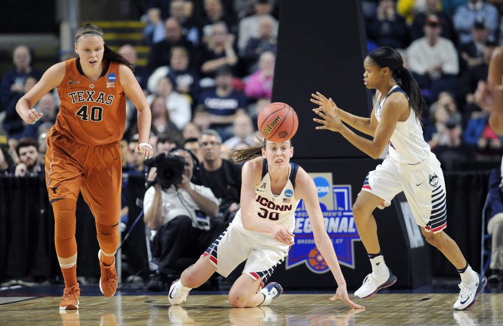 Breanna Stewart flips the ball to Moriah Jefferson, right, to start a fast break as Texas’ Kelsey Lang pursues in the first half of Monday night’s win by the Huskies.