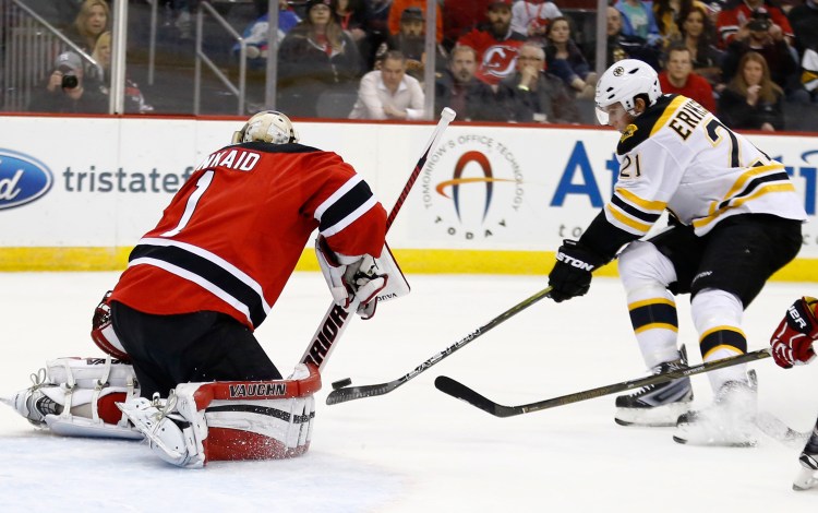 New Jersey goalie Keith Kinkaid makes a save as Boston's Loui Eriksson skates in front of the net during the Devils' 2-1 win Tuesday night.   The Associated Press