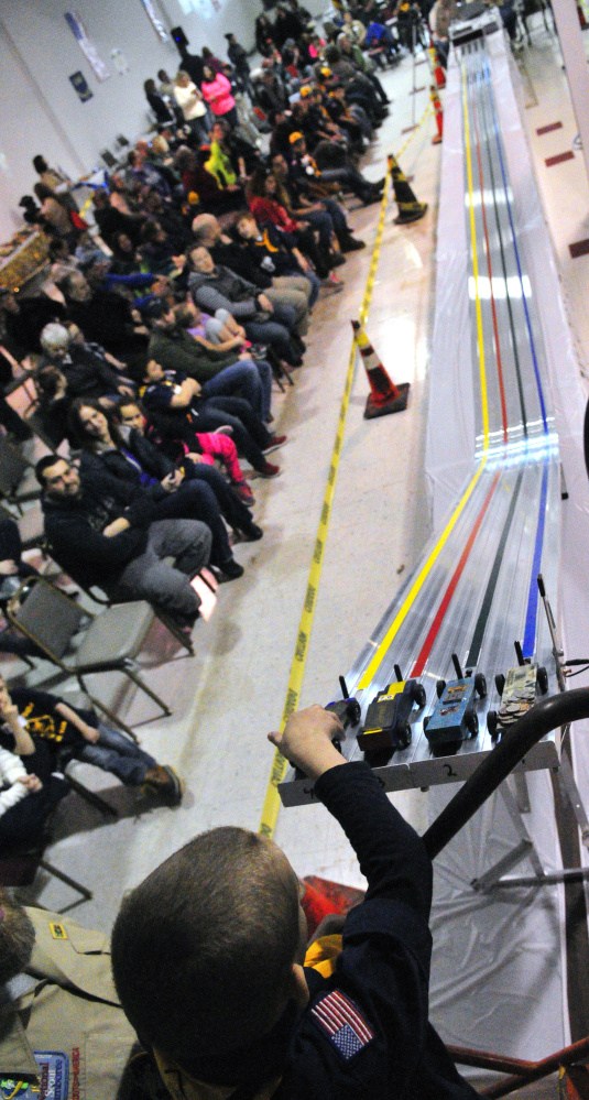 A cub scout sets his car at the top of the ramp Saturday during the Kennebec Valley District Pinewood Derby in Augusta.