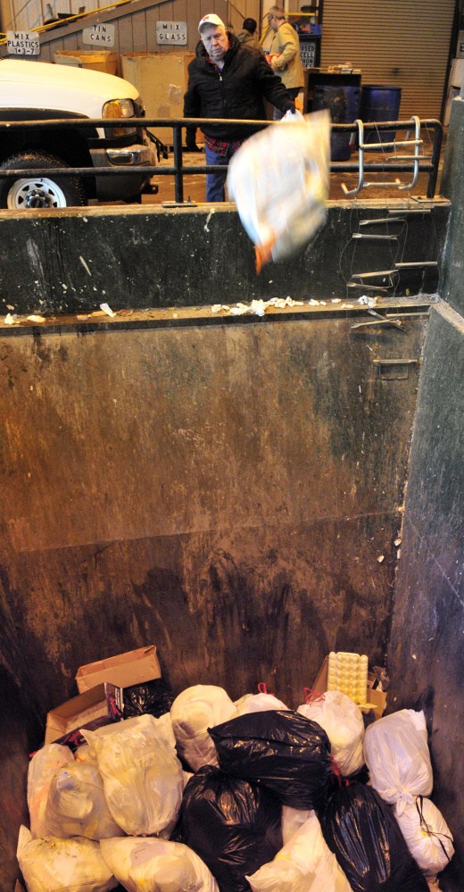 Irving Doughty tosses a trash bag on Feb. 5 at the Winthrop Transfer Station, which will be sending its trash to Auburn starting in 2018.