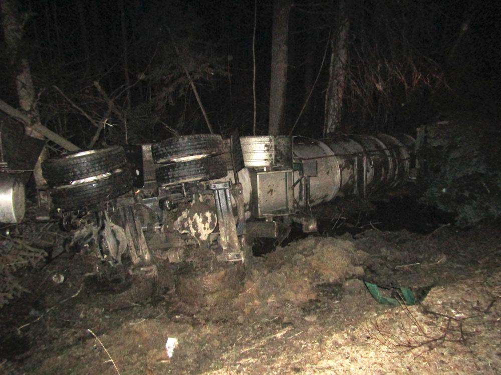 A Poland Spring Water Company truck lies on its side after rolling over just before 1 a.m. Wednesday on the shoulder of Route 27 in New Vineyard.