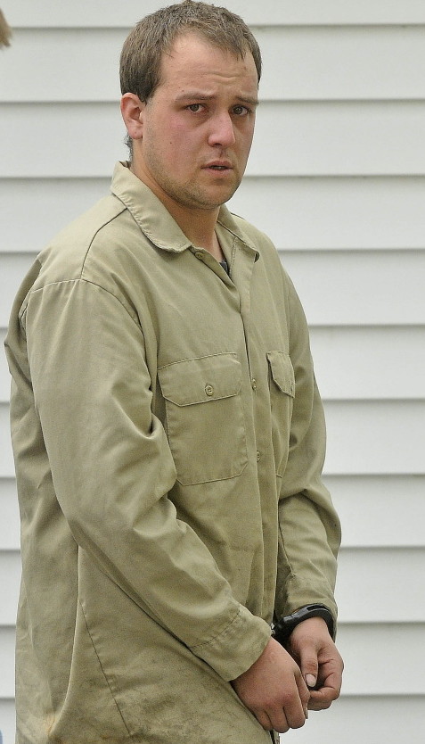 David Devine, now 27, is escorted to a police cruiser May 23, 2014, after being booked for two counts of aggravated assault at the Oakland Police Department.