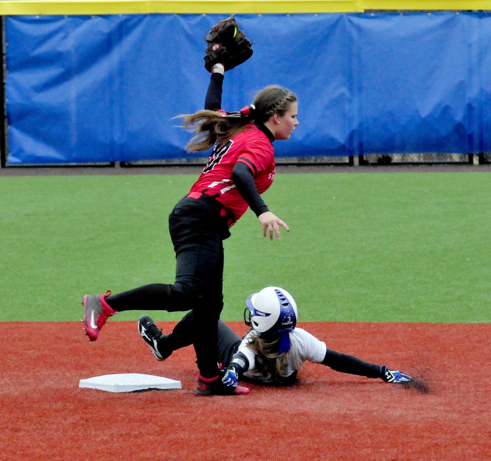 Thomas College player Cassie Contigiani holds up the ball after tagging out Colby's Robin Spofford at second base during a game on Monday in Waterville.
