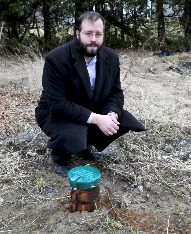 Winslow homeowner Cory Dow stands beside the top of a drilled well Monday at his home. Dow is asking the town to reimburse him for the cost of connecting to public water after his well showed salt contamination, which the state Department of Environmental Protection concluded was caused by runoff from the town's nearby salt and sand shed.