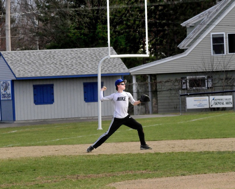 During a recent practice, Josiah Webber fields a ball from third base at the Lawrence High School baseball field. Looming in left field a few feet from the foul line is one of the goal posts at the adjacent Keyes football field.