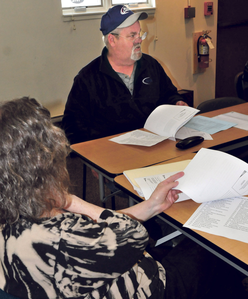 Marshall Cox asks questions Wednesday during a job fair preparation workshop at the Waterville Public Library, as Leslie Wright reads material.